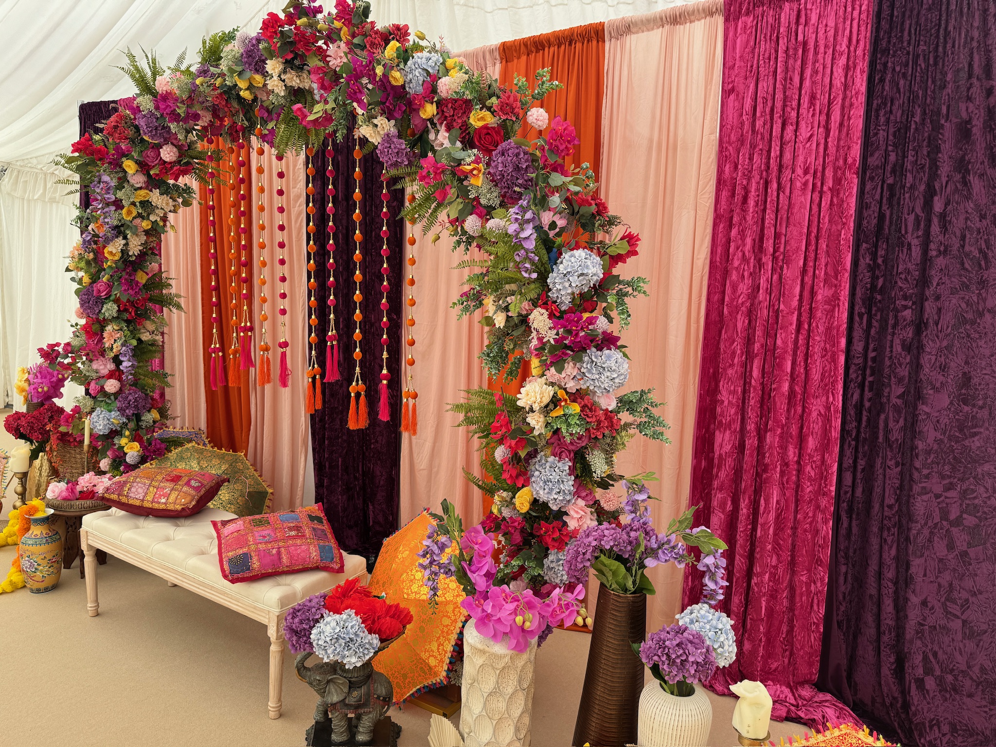 Colourful floral arch with draping — Regiis Events